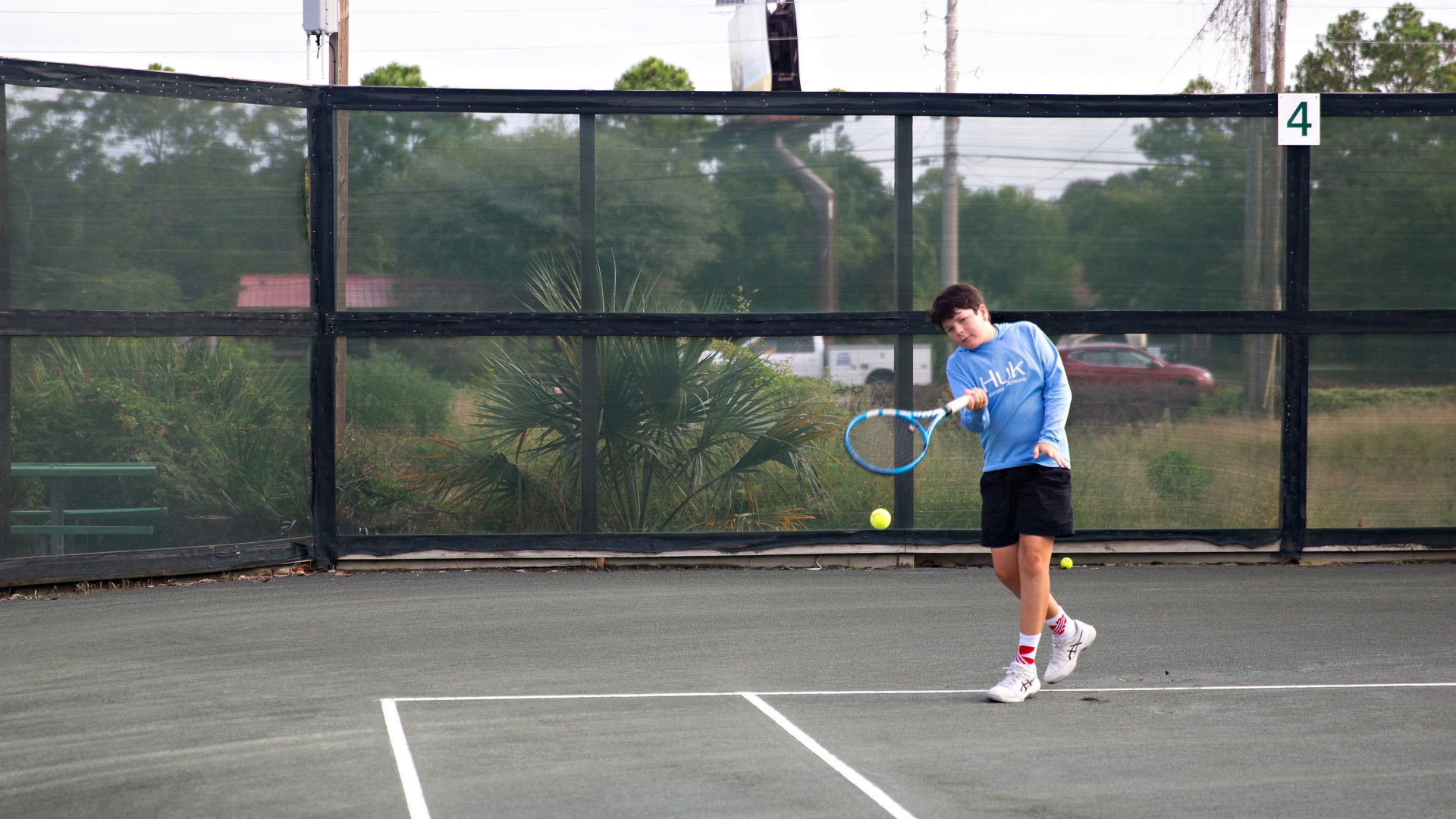 A young boy hitting a tennis ball